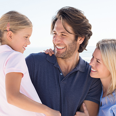 Cheerful small family enjoying holiday at beach.