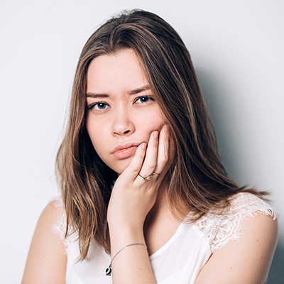 Unhappy woman feel pain on her teeth isolated on white background,