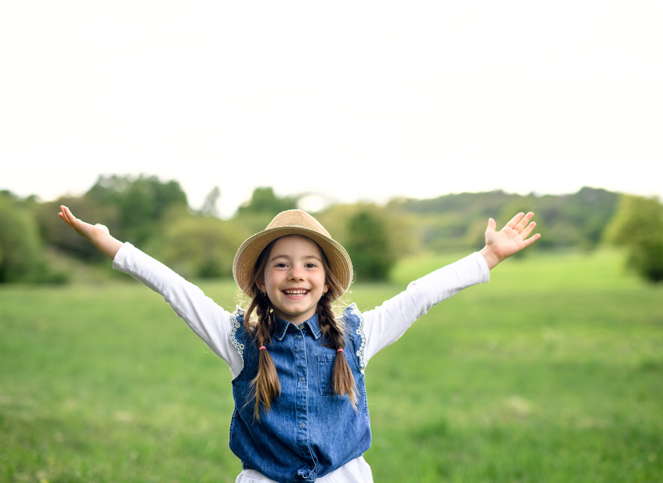 Portrait of small girl standing outdoors in spring nature.
